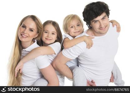 Parents and two children. Parents giving two children piggyback rides smiling isolated on white background