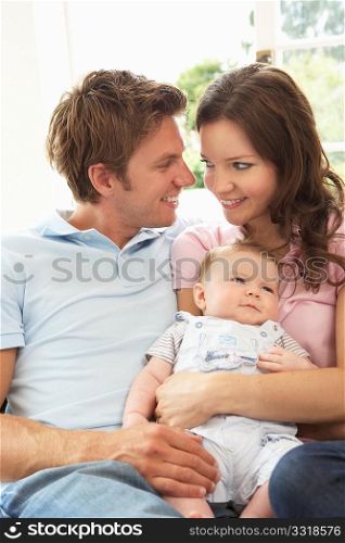 Parents Cuddling Newborn Baby Boy At Home