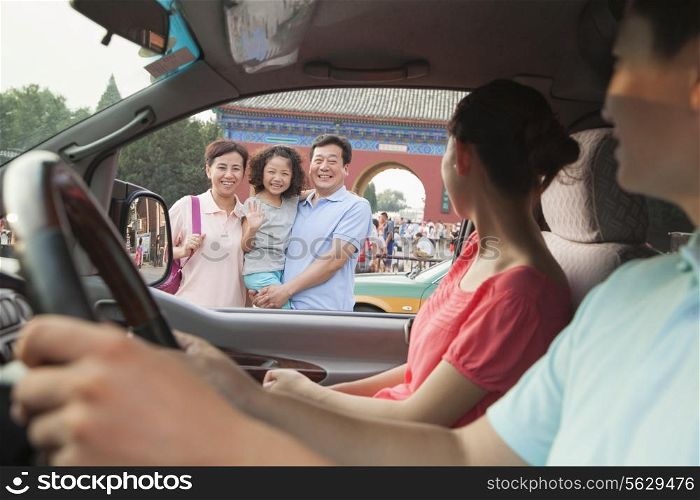 Parents driving and saying good bay to son and grandparents