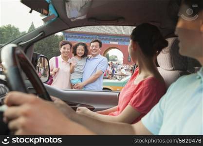 Parents driving and saying good bay to son and grandparents
