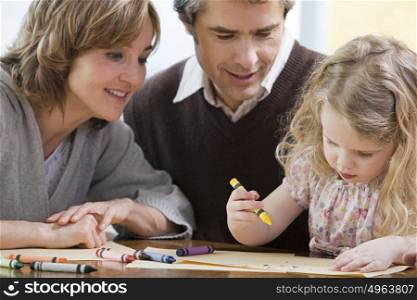 Parents helping their daughter draw