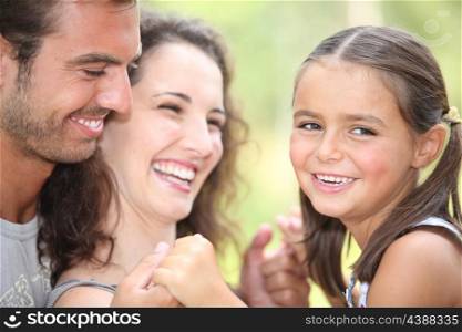 Parents laughing with their daughter