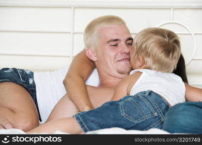 Parents lying down on a bed with their son