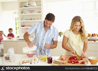 Parents Preparing Family Breakfast In Kitchen
