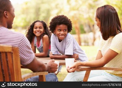 Parents Relaxing Whilst Children Play In Garden