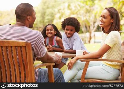 Parents Relaxing Whilst Children Play In Garden