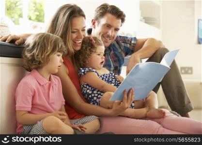 Parents Sitting With Children Reading Story Indoors