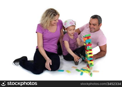 Parents stacking bricks with their daughter