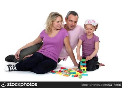 Parents watching their daughter play with blocks