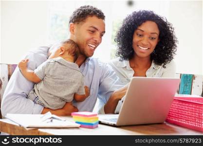 Parents With Baby Working In Office At Home