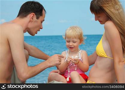 parents with child on sea shore