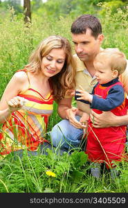 Parents with child sit in grass