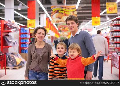 Parents with children in supermarket, focus on little girl