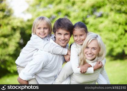 Parents with children on shoulders outdoors