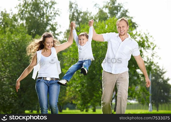 Parents with the small son frolic on the nature