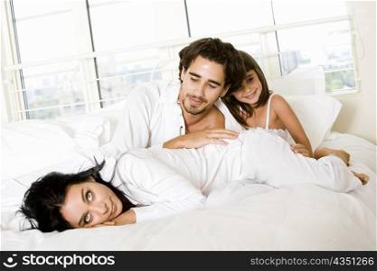 Parents with their daughter on the bed