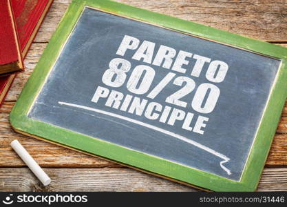 Pareto principle or eighty-twenty rule - white chalk text on a vintage blackboard blackboard with books