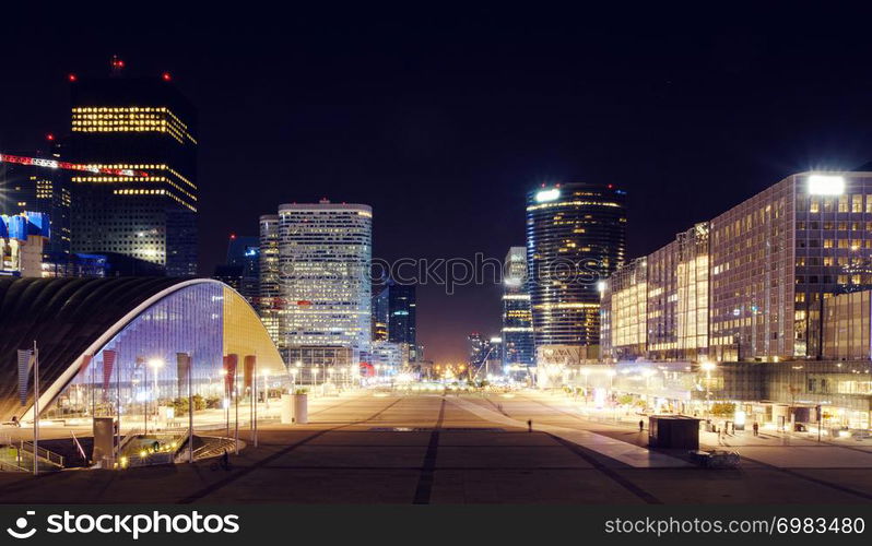 Paris city at night with business buildings and glass towers with lights, France. The city of Paris at night