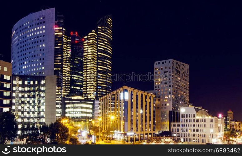 Paris city at night with business centers and glass towers with lights, France. The city of Paris at night