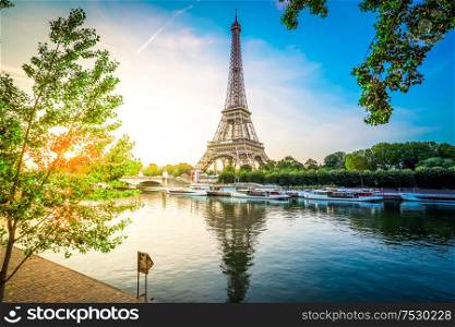 Paris Eiffel Tower and river Seine with sunrise sun in Paris, France. Eiffel Tower is one of the most iconic landmarks of Paris, toned. eiffel tour over Seine river
