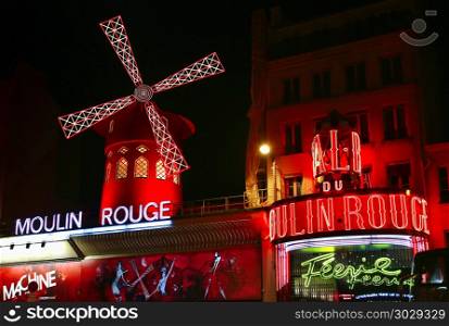 PARIS / FRANCE - 30 APRIL 2017: View of the Moulin Rouge (Red Mill) at night in Paris, a landmark cabaret in the Montmartre neighborhood of the French capital.. View of the Moulin Rouge (Red Mill) at night in Paris, France