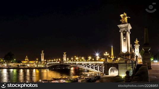 PARIS, FRANCE - JULY 14 2014  The Eiffel Tower and Pont Alexandre III at night in Paris, France, July 14, 2014