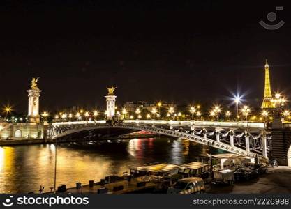 PARIS, FRANCE - JULY 14 2014  The Eiffel Tower and Pont Alexandre III at night in Paris, France, July 14, 2014
