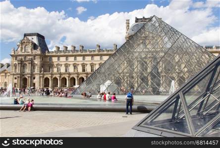 PARIS - JULY 28, 2013. Tourists enjoy the weather at the Louvre on July 28, 2013 in Paris. The Louvre contains more than 380.000 objects and displays 35.000 artworks in eight departments. Paris, July 28, 2013