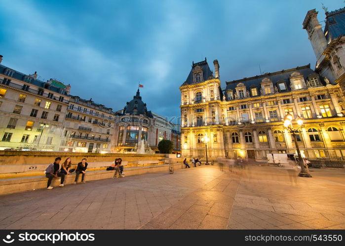 PARIS - JUNE 2014: Hotel de Ville at night with tourists. Paris attracts 30 million people annually.