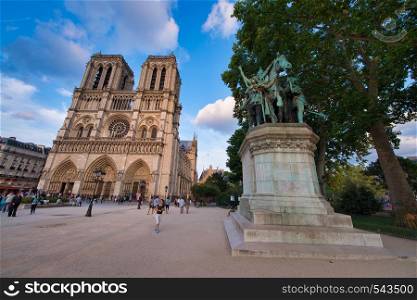PARIS - JUNE 2014: Notre Dame Cathedral at sunset with tourists. Notre Dame is visited by 12 million people every year.