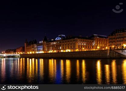 Paris. Quay in the night light.. Embankment along the Conciergerie and the river Seine at night. Paris. France.