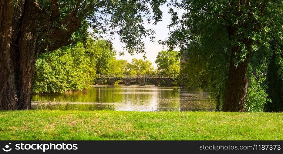 Park with lake and stone bridge, old European town. Summer tourism and travels, famous europe landmark, popular places for tourists