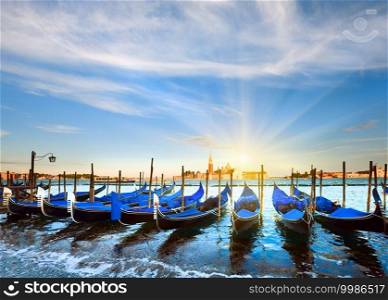 Parked gondolas on Piazza San Marco and The Doge Palace embankment and sunset sunshine  Venice, Italy 