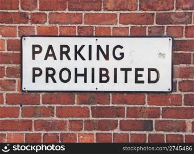 parking prohibited vintage sign at a red brick wall background