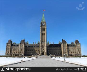 Parliament of Canada in the Canadian capital city of Ottawa Ontario as an historic and iconic building with a front view of the peace tower during winter or early spring.