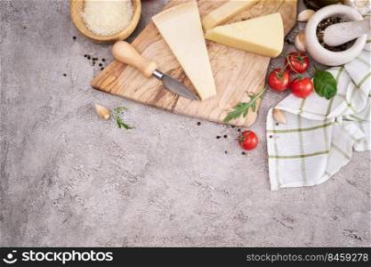 Parmesan cheese and knife on a wooden cutting board.. Parmesan cheese and knife on a wooden cutting board