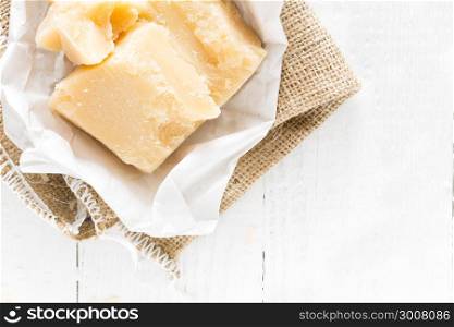 Parmesan cheese on white wooden background