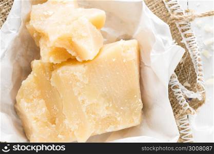 Parmesan cheese on white wooden background
