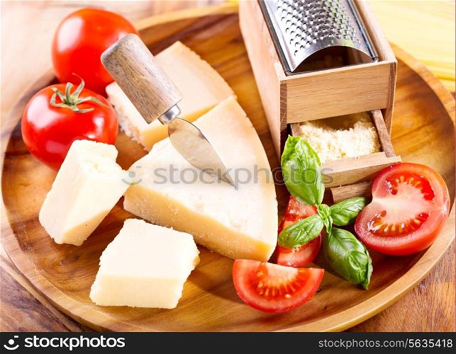parmesan cheese with grater on woode plate