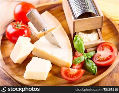 parmesan cheese with grater on woode plate