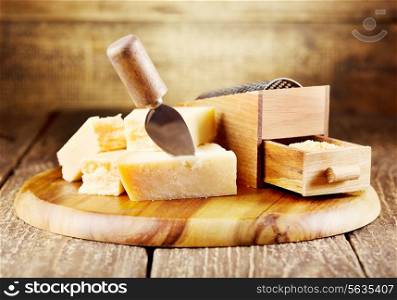 parmesan cheese with grater on wooden background