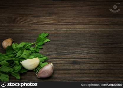 Parsley and garlic. Rustic composition on a wooden background.
