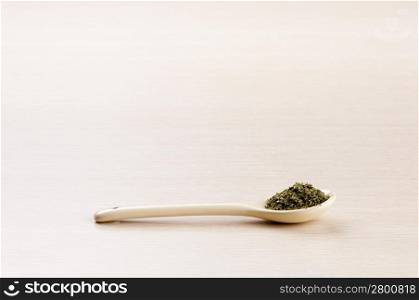 Parsley in a spoon over a blured wooden background with copy space