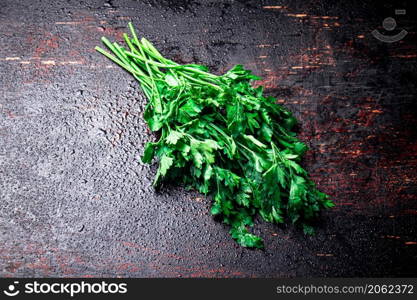 Parsley on a damp table. Against a dark background. High quality photo. Parsley on a damp table.