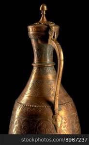 Part ancient oriental metal jug on dark background. Antique bronze tableware. ancient metal utensils