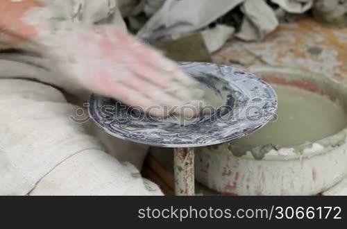 Part I. Potter&acute;s hands making a pot in traditional style.