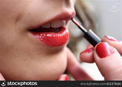 Part of attractive woman&rsquo;s face with fashion red lips makeup. Make-up artist apply bloody lipstick