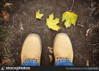 part of boots and leaves on the ground, natural soft light, selective focus