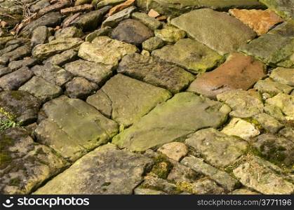 Part of cobblestone pavement in wet weather closeup as background