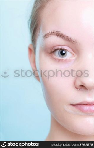 Part of face. Portrait of blond girl young woman in facial peel off mask. Peeling. Beauty and body skin care. Blue background. Studio shot.